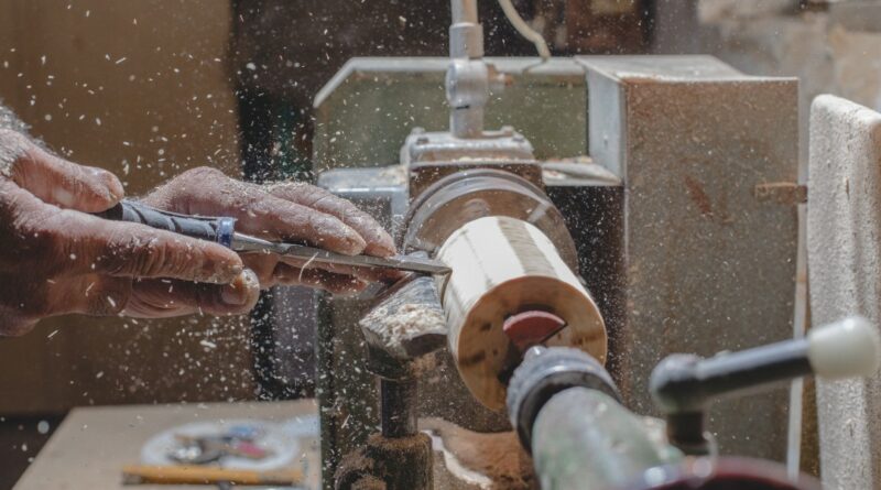 Immagine di un artigiano che lavora il legno con una fresa elettrica